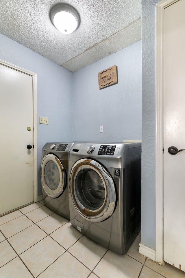 laundry room with washing machine and dryer and light tile patterned floors