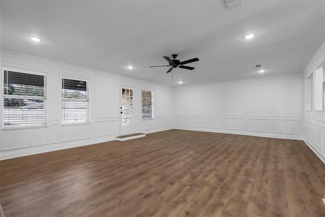 spare room with ornamental molding, dark wood-type flooring, a ceiling fan, and a decorative wall