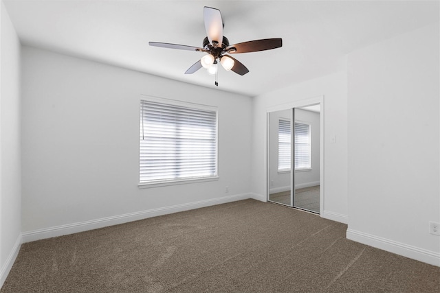 unfurnished bedroom with a closet, carpet, a ceiling fan, and baseboards