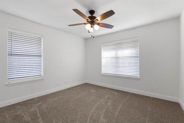 empty room featuring carpet floors, a ceiling fan, and baseboards