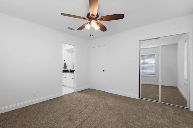 unfurnished bedroom featuring light colored carpet, visible vents, ensuite bathroom, a ceiling fan, and baseboards