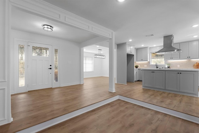 foyer featuring a wealth of natural light, light wood-style flooring, baseboards, and recessed lighting