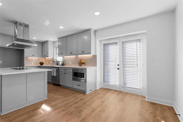 kitchen with island range hood, stainless steel appliances, a sink, and gray cabinetry