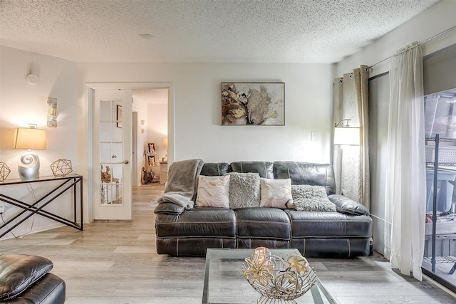 living room with a textured ceiling and light hardwood / wood-style floors