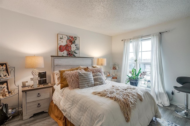 bedroom with wood-type flooring and a textured ceiling