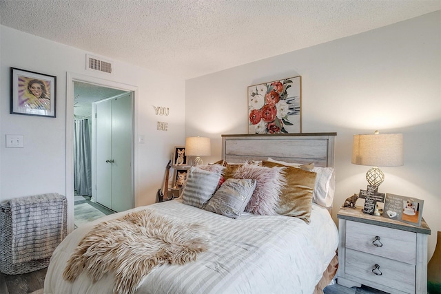 bedroom featuring hardwood / wood-style flooring and a textured ceiling