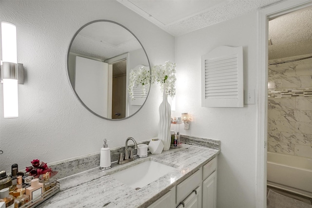 bathroom featuring vanity, tiled shower / bath combo, and a textured ceiling