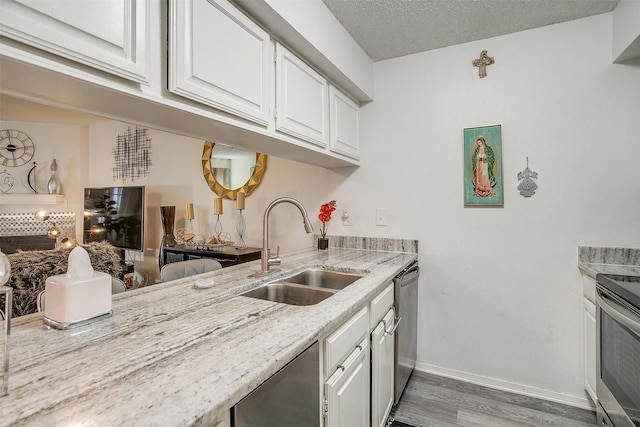 kitchen with sink, white cabinetry, light stone countertops, a textured ceiling, and dark hardwood / wood-style flooring