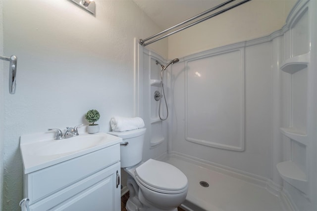 bathroom with a shower, vanity, and toilet