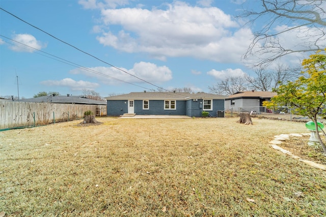 rear view of property with a yard and central AC unit