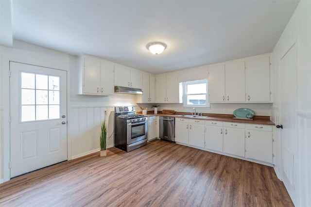 kitchen featuring a healthy amount of sunlight, stainless steel appliances, sink, and white cabinets