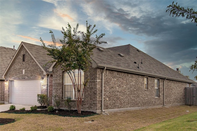 property exterior at dusk with a yard and a garage