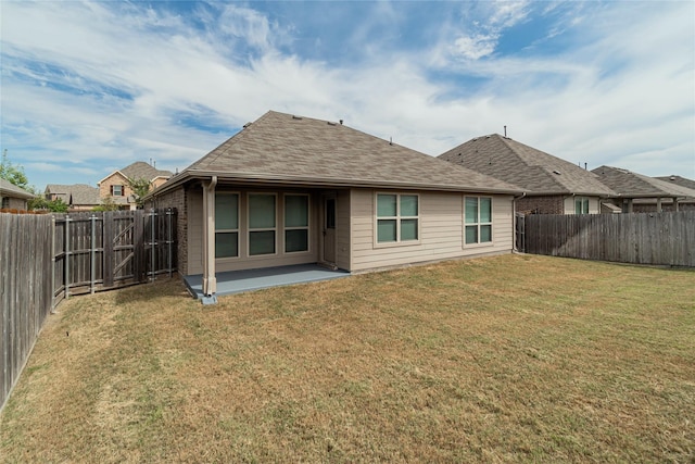 back of property with a yard and a patio