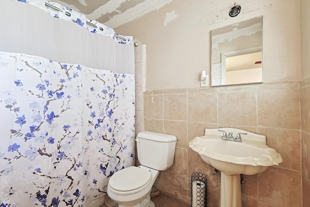 bathroom with tile walls, toilet, and a shower with shower curtain