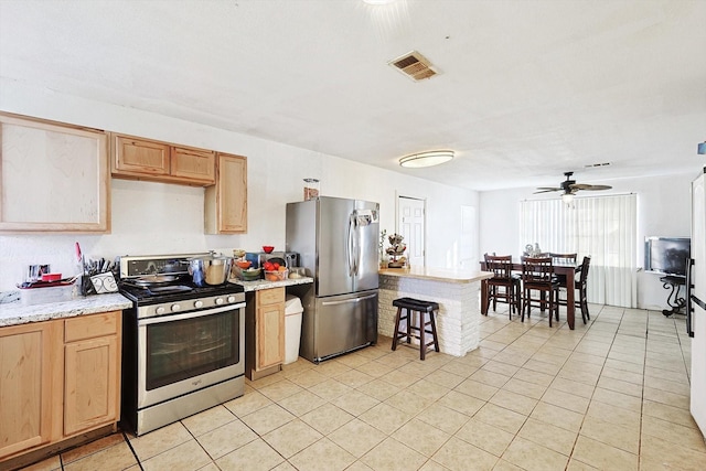 kitchen with ceiling fan, appliances with stainless steel finishes, and light tile patterned floors