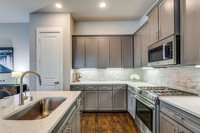 kitchen featuring light stone counters, stainless steel appliances, sink, and tasteful backsplash