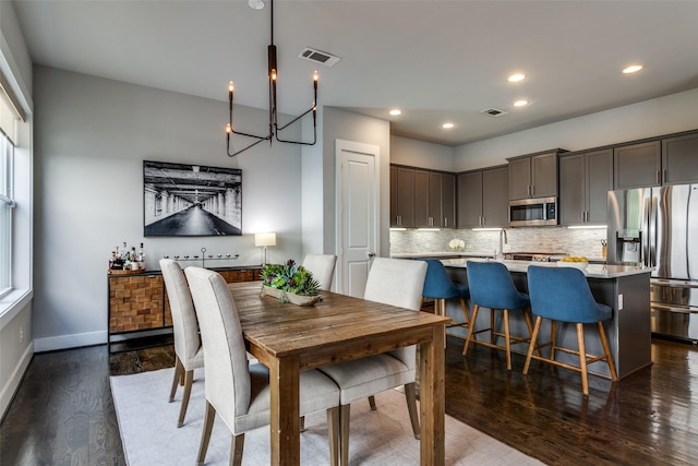 dining space featuring dark wood-type flooring and a chandelier