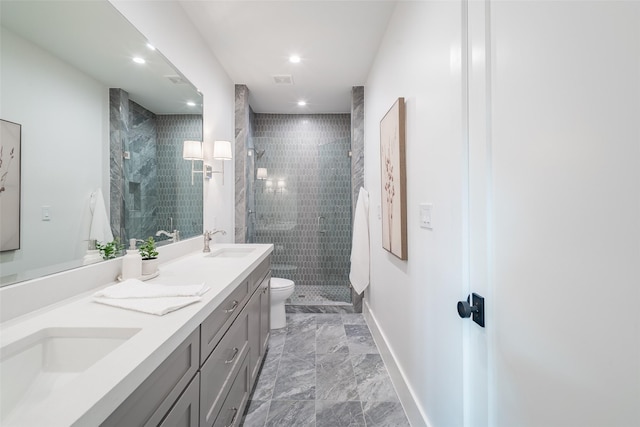 bathroom with a tile shower, vanity, and toilet