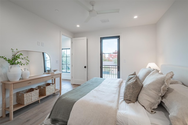 bedroom with ceiling fan, access to exterior, hardwood / wood-style floors, and multiple windows