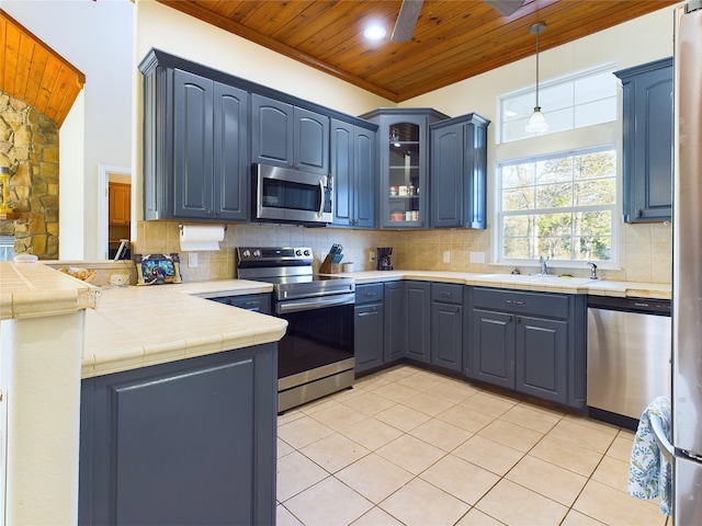 kitchen with sink, decorative light fixtures, wooden ceiling, appliances with stainless steel finishes, and kitchen peninsula