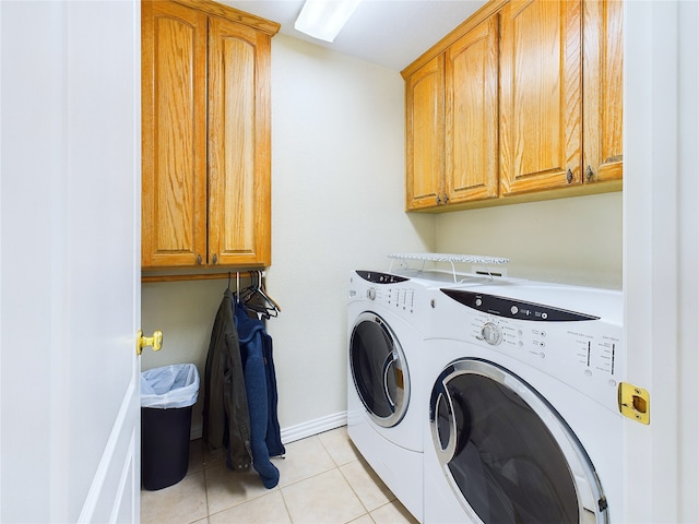 laundry area with light tile patterned floors, cabinets, and independent washer and dryer