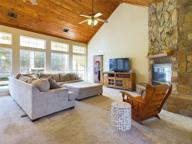 carpeted living room featuring ceiling fan, a stone fireplace, wood ceiling, and high vaulted ceiling