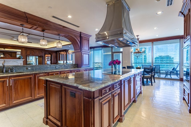 kitchen featuring sink, island range hood, a kitchen island, pendant lighting, and black electric stovetop