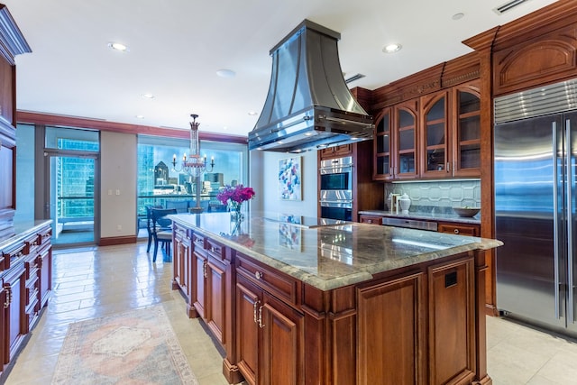 kitchen with pendant lighting, backsplash, stainless steel appliances, island range hood, and a kitchen island