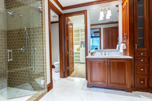 bathroom featuring vanity, a shower with door, ornamental molding, and toilet