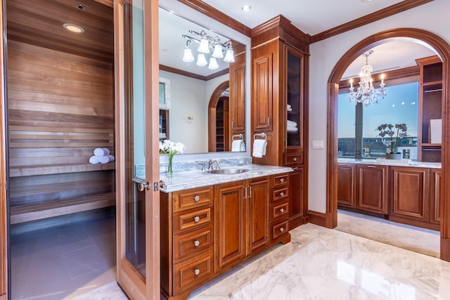 bathroom featuring vanity, ornamental molding, and a chandelier