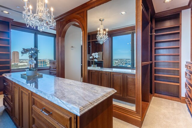 kitchen featuring a chandelier, a center island, light carpet, and pendant lighting