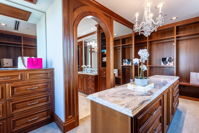 walk in closet featuring an inviting chandelier and light carpet