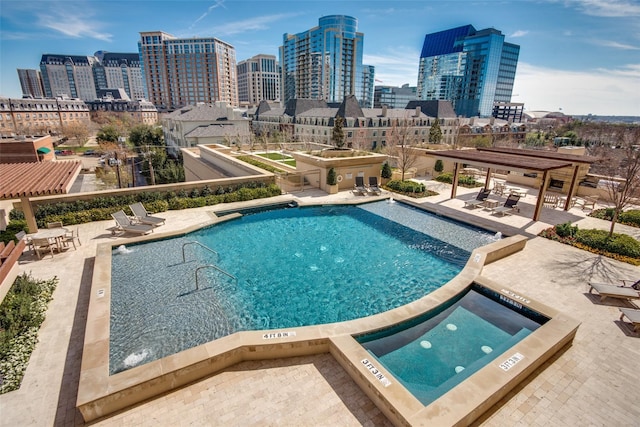 view of pool featuring a community hot tub and a patio area