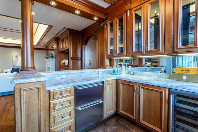 bar featuring wine cooler, light stone counters, dark wood-type flooring, and decorative columns