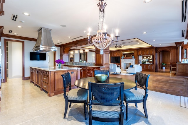 tiled dining room with ornamental molding, a tray ceiling, and a notable chandelier