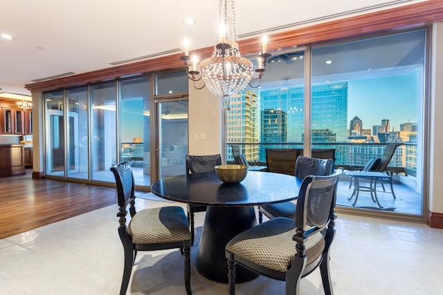 dining area with expansive windows, hardwood / wood-style floors, and a notable chandelier