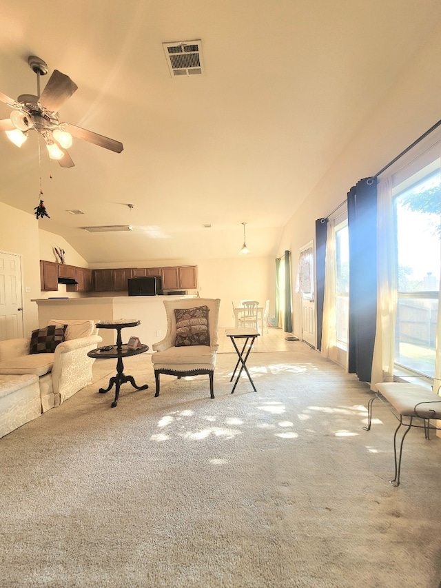 living room featuring light carpet, lofted ceiling, and ceiling fan