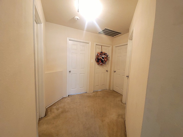 hallway featuring light colored carpet