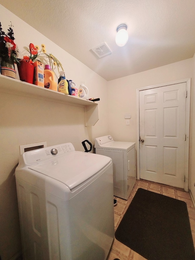 washroom with washer and clothes dryer and light tile patterned floors