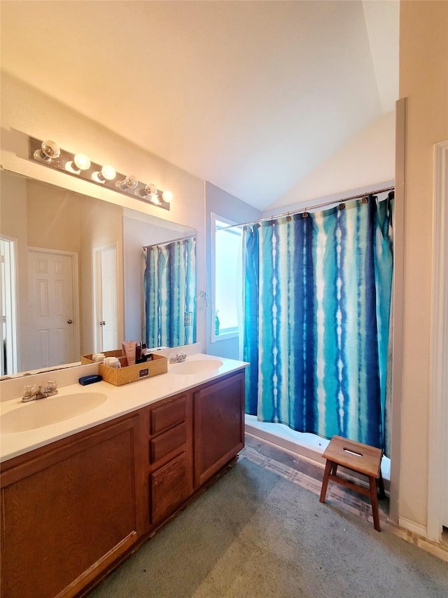 bathroom with lofted ceiling and vanity