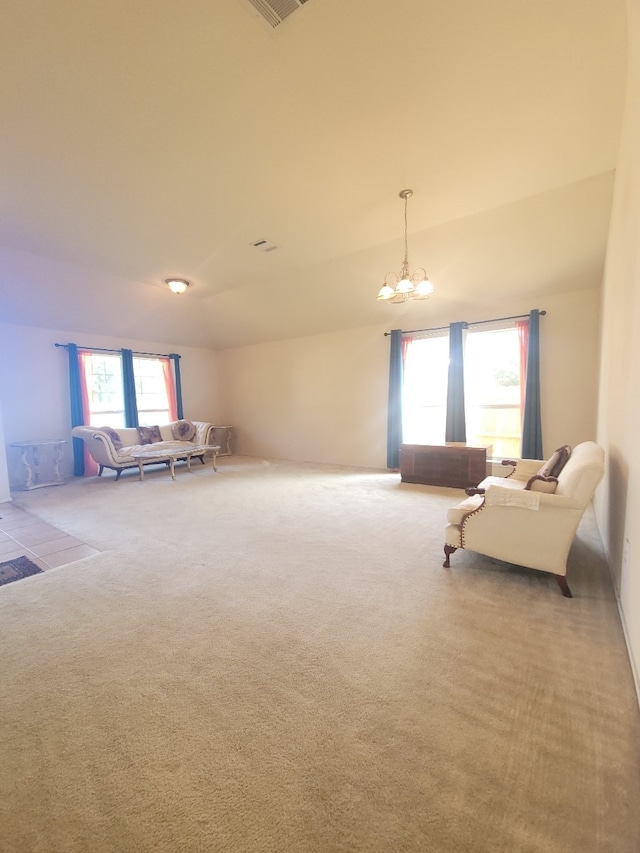 carpeted living room featuring a notable chandelier and vaulted ceiling