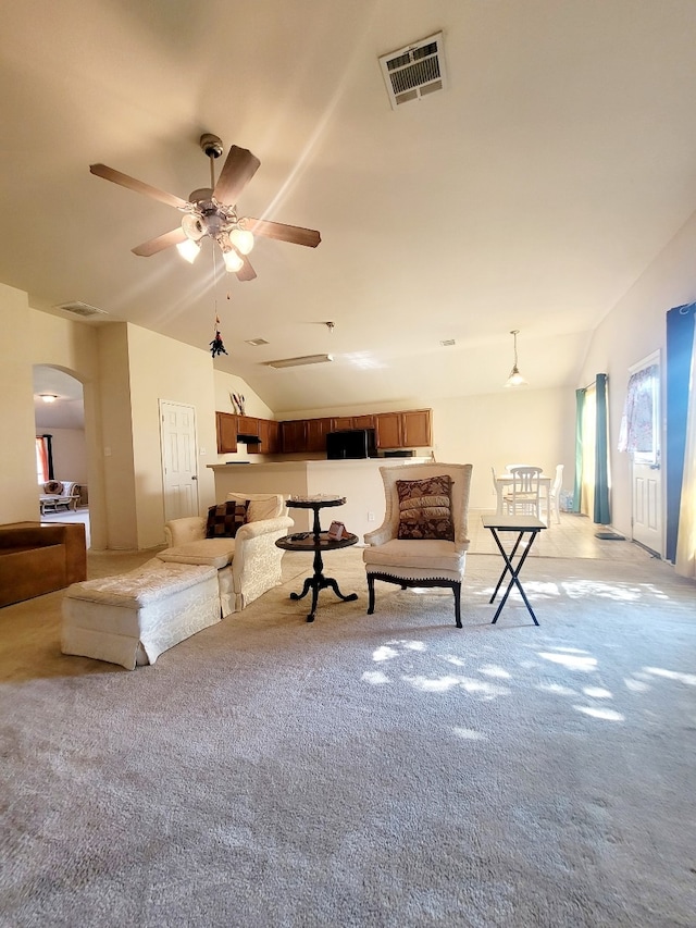 unfurnished living room featuring lofted ceiling, light colored carpet, and ceiling fan