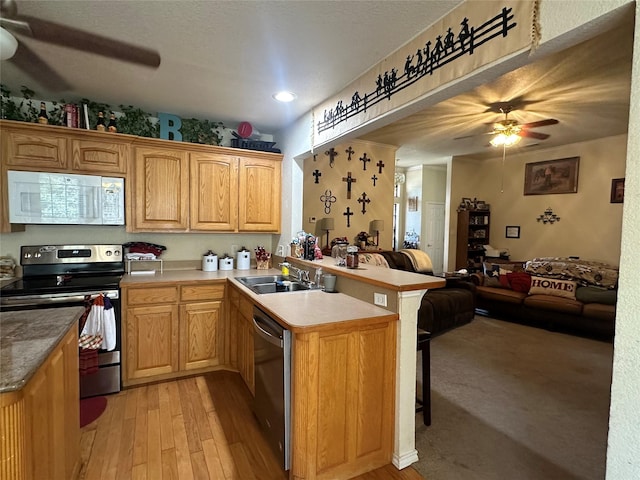 kitchen featuring sink, kitchen peninsula, ceiling fan, and appliances with stainless steel finishes