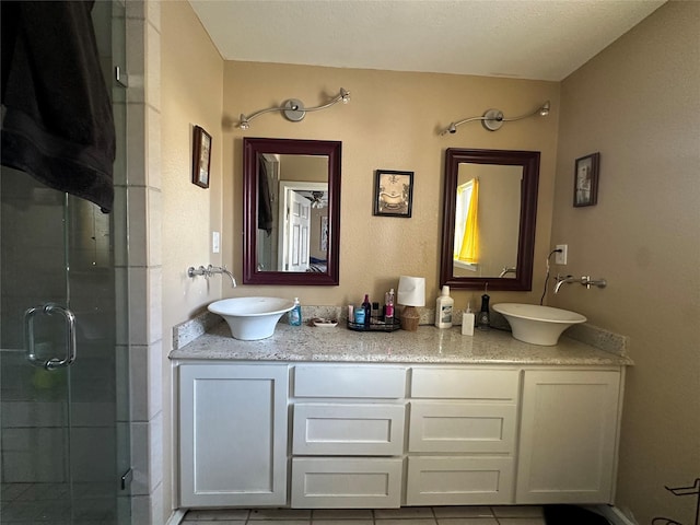 bathroom with tile patterned flooring, vanity, and a shower with shower door