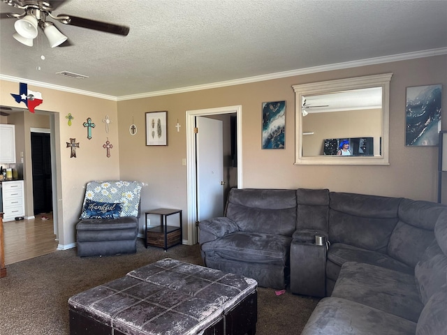 carpeted living room featuring ornamental molding, ceiling fan, and a textured ceiling