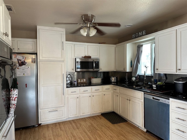 kitchen with sink, ceiling fan, stainless steel appliances, light hardwood / wood-style floors, and white cabinets