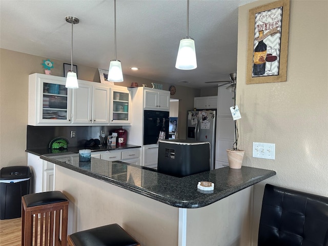 kitchen with white cabinetry, a kitchen breakfast bar, and kitchen peninsula