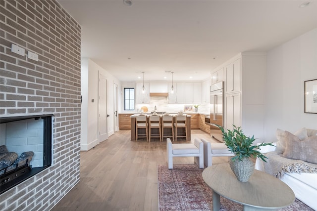 living room featuring a large fireplace and light hardwood / wood-style floors