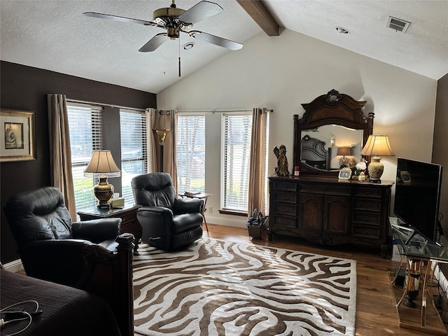 living room featuring lofted ceiling with beams, ceiling fan, hardwood / wood-style floors, and a textured ceiling