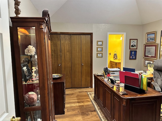 office area with vaulted ceiling and light wood-type flooring